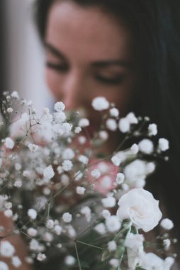 Güzel bir esmer kız yüzü ve taze çiçekler.