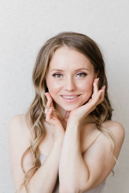 Güzel genç kız yüzüne dokunuyor. Doğal ve doğal güzellik.
