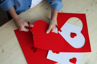  Kırmızı kağıt kalpli DIY tatil kartı, aşkın sembolü. Çocuk Anneler Günü 'nde, Sevgililer Günü' nde, doğum günü tebrik kartında. Hobi, çocuk sanatı konsepti, kendi ellerinle hediye, çocuklar için fikirler.