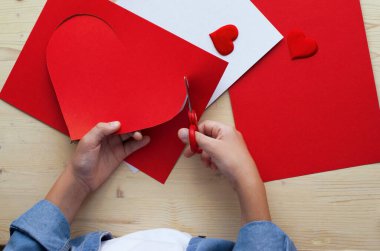  Kırmızı kağıt kalpli DIY tatil kartı, aşkın sembolü. Çocuk Anneler Günü 'nde, Sevgililer Günü' nde, doğum günü tebrik kartında. Hobi, çocuk sanatı konsepti, kendi ellerinle hediye, çocuklar için fikirler.