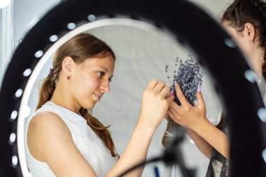 Manikürcü, kuaförde akıllı telefonuyla tırnak işçiliğinin fotoğraflarını çekiyor. Genç Güzellik Etkilendirici blogcu blog, vlog için içeriği fotoğraflıyor. Çevrimiçi Çivi Fotoğrafçılık Kursu, blog yazma