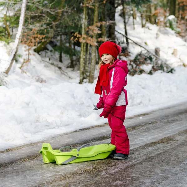 Маленька дівчинка зі сніговими санчатами — стокове фото