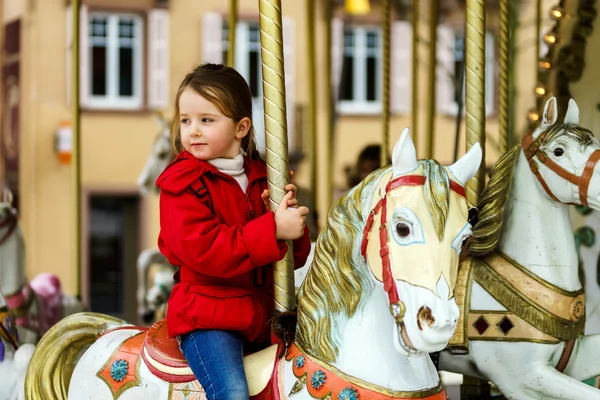 Little girl sitting on carousel horse — Stock Photo, Image