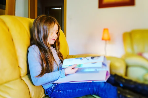 Cute little girl with long hair reading children book in livivng — Stock Photo, Image