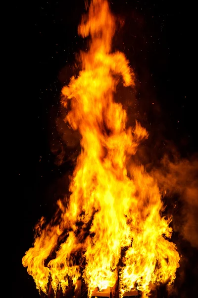 Techo de casa de madera en el fuego sobre fondo negro —  Fotos de Stock