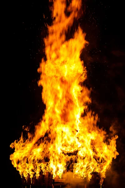 Techo de casa de madera en el fuego sobre fondo negro —  Fotos de Stock