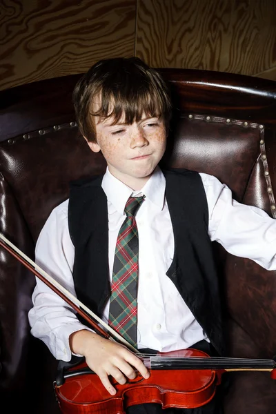 Niño pecoso de pelo rojo con violín sentado en el sillón — Foto de Stock