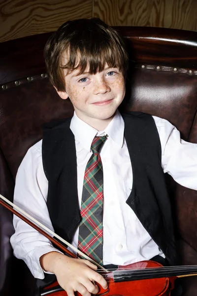 Freckled red-hair boy with violin sitting in the arm-chair — Stock Photo, Image