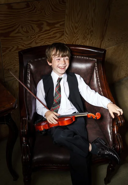 Pihovatý chlapec červené vlasy s housle sedí v křesle — Stock fotografie
