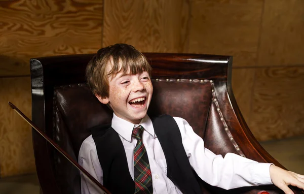 Freckled red-hair boy with violin sitting in the arm-chair — Stock Photo, Image