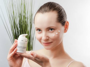 Temiz Taze Ciltli Güzel Genç Kadın cilt bakımı için ürünü gösteriyor. Güzel kız yüz bakımı. Yüz bakımı. Kozmetik, güzellik ve kaplıca. Doğal kozmetik ürünü. Organik BiyoKozmetik Konsepti. Beyaz arkaplanda izole.