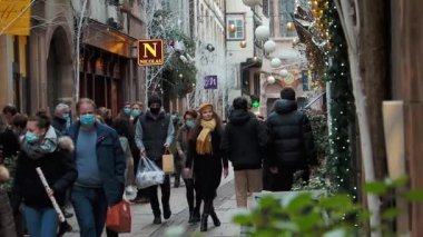 Strasbourg 'da işlek bir alışveriş caddesi. Salgının olduğu zaman. Herkes maske takıyor. Güzel bir kız kalabalığın içinde yürüyor..