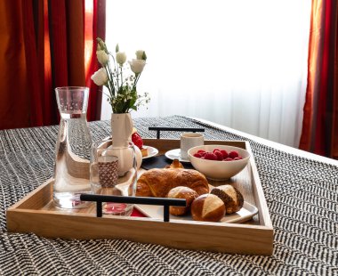 Yatakta kahvaltı. Ahududu, kahve, kek, kruvasan. Samimi bir otel. Turizm ve seyahat.