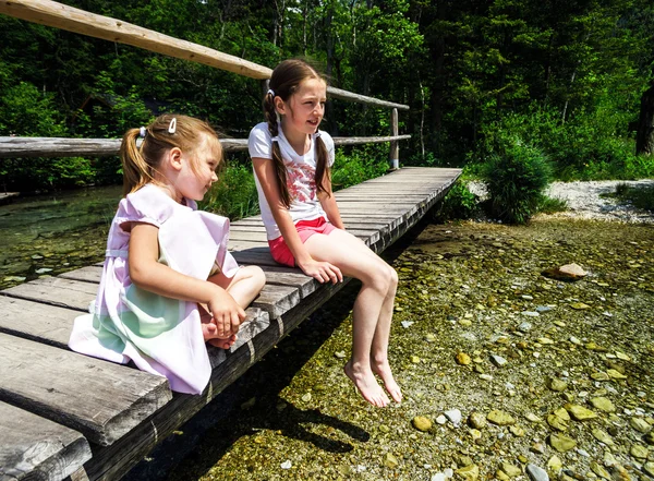 Twee systers zitten over de rivier — Stockfoto