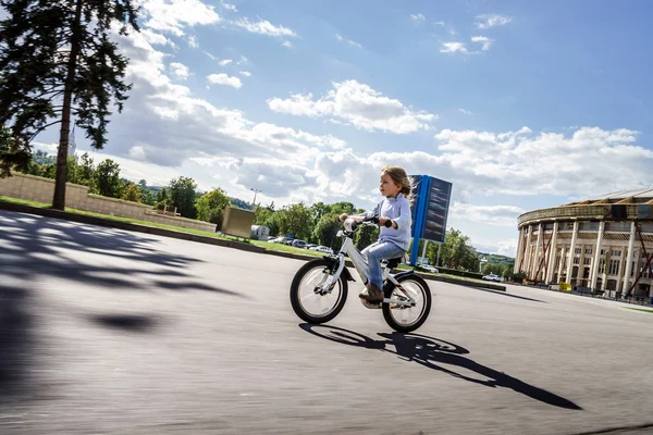 Petite fille mignonne chevauchant rapidement à vélo — Photo