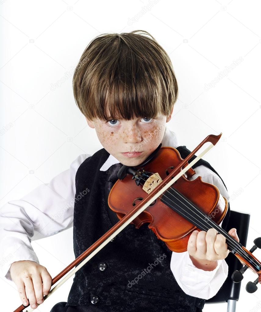 Red-haired preschooler boy with violin