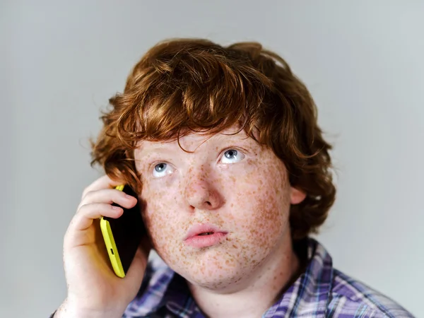 Comico lentigginoso ragazzo dai capelli rossi con il telefono cellulare — Foto Stock