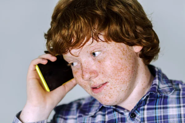 Комический рыжеволосый мальчик с мобильным телефоном — стоковое фото