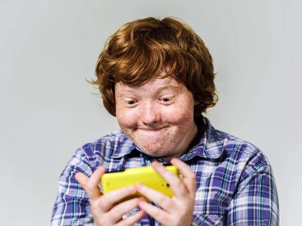 Comic freckled red-haired boy with mobile phone — Stock Photo, Image