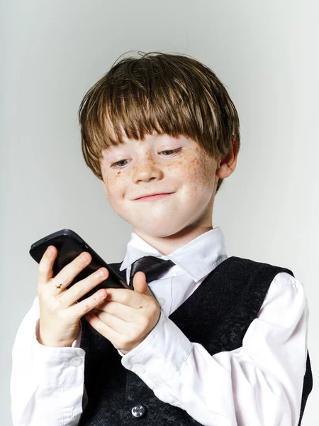 Emotionele roodharige jongen met mobiele telefoon — Stockfoto