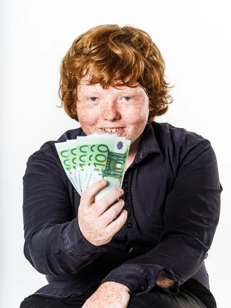 Gelukkig roodharige jongen met geld — Stockfoto