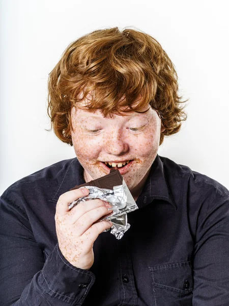 Happy red-haired boy with chocolate bar — Stock Photo, Image