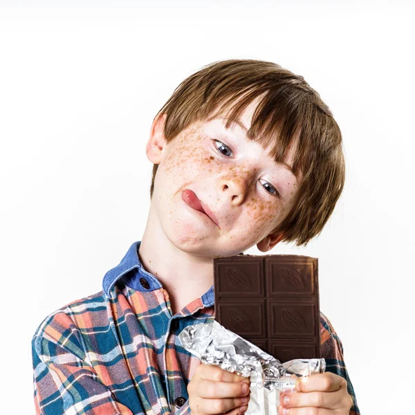 Fericit băiat cu păr roșu cu bar de ciocolată — Fotografie, imagine de stoc