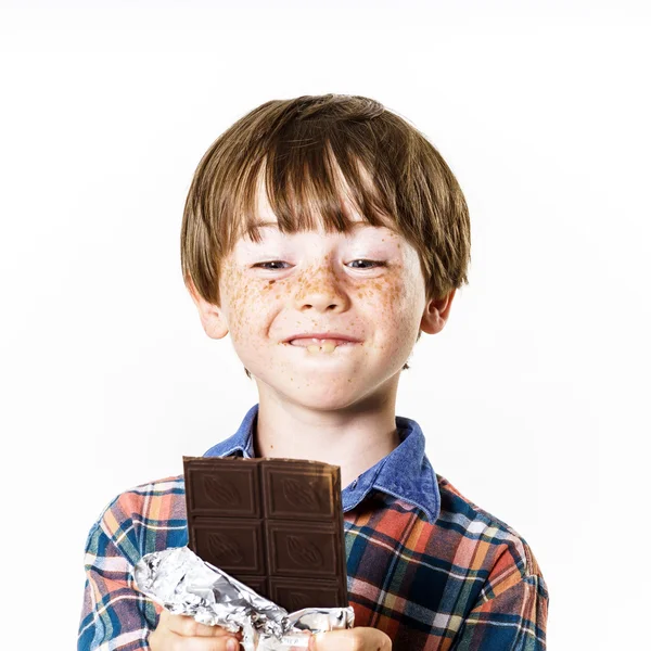 Joyeux garçon aux cheveux roux avec barre de chocolat — Photo