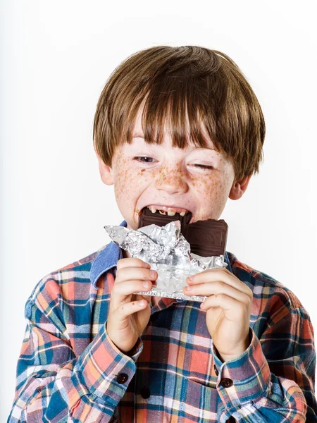 Joyeux garçon aux cheveux roux avec barre de chocolat — Photo