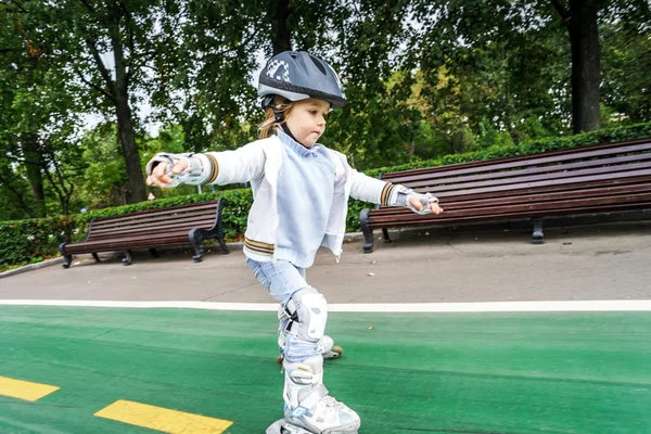 Nettes kleines Mädchen lernt Rollschuhlaufen — Stockfoto