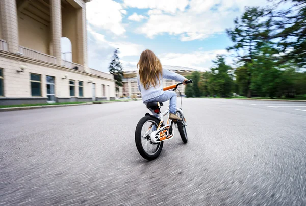 Roztomilá holčička na koni rychle na kole — Stock fotografie