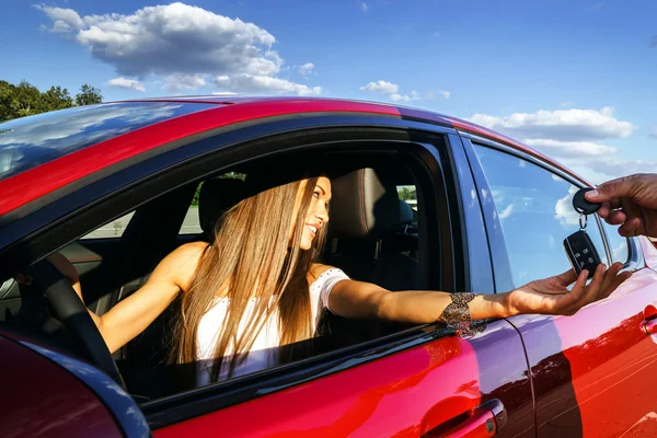 Ung kvinna ta nycklarna till nya bilen — Stockfoto