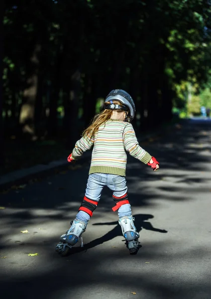 Nettes kleines Mädchen lernt Rollschuhlaufen — Stockfoto