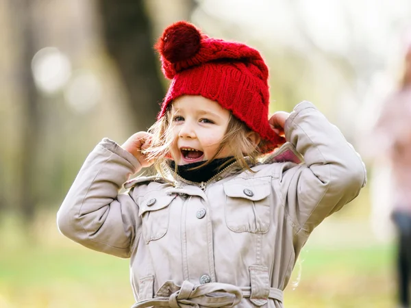 Linda niña en el parque infantil en el parque otoñal —  Fotos de Stock