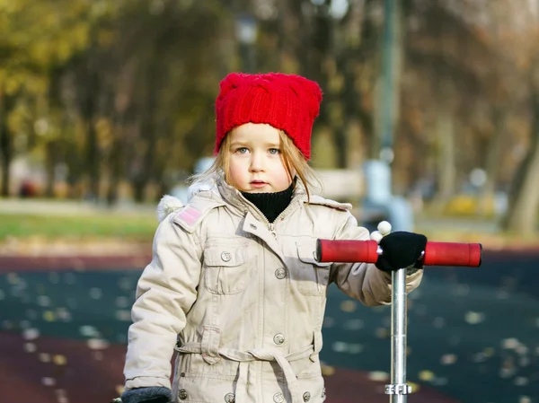 Sevimli küçük kız oyun sonbahar Park üzerinde — Stok fotoğraf