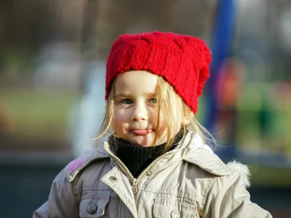 Cute little girl on playground in autumnal park — Stock Photo, Image