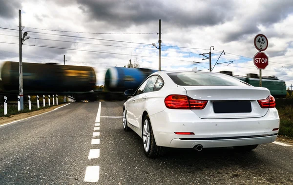 Carro branco de luxo esperando na travessia ferroviária — Fotografia de Stock