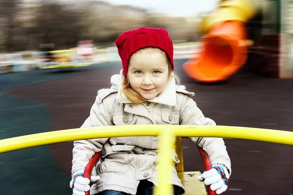 Menina bonito arredondamento em alegre-go-round — Fotografia de Stock