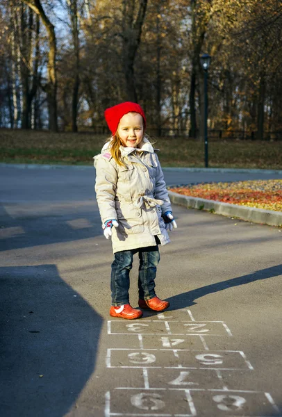 Petite fille mignonne jouant sur l'aire de jeux pour enfants dans le parc public — Photo