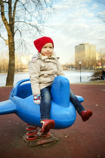 Roztomilá holčička hraje na dětské hřiště ve veřejném parku — Stock fotografie
