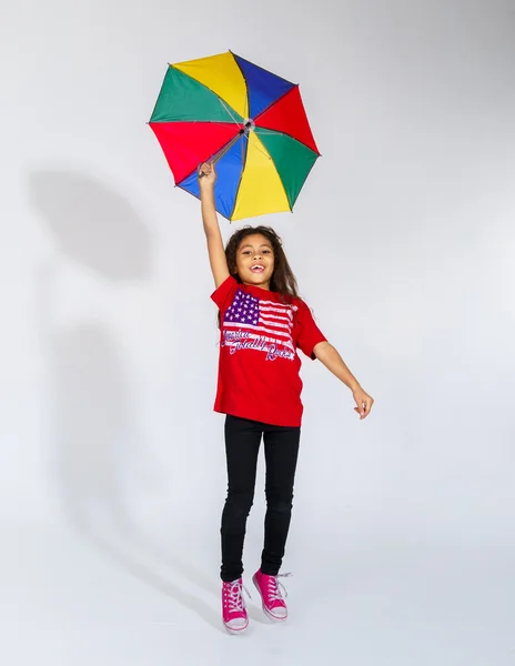 Sevimli küçük gülümseyen Afro-Amerikan kız ile renkli umb atlama — Stok fotoğraf