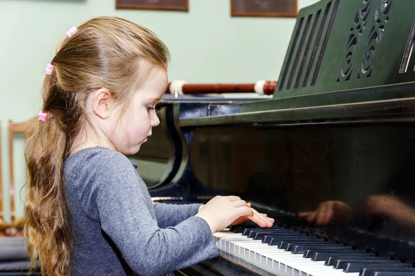 Menina bonito tocando piano de cauda — Fotografia de Stock