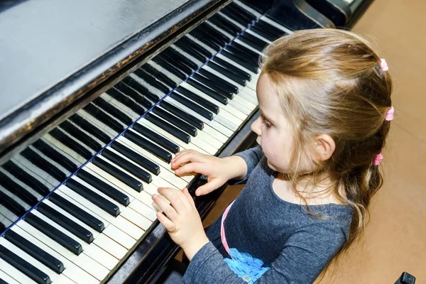 Cute little girl playing grand piano — Stock Photo, Image