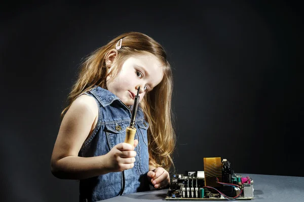 Cute little girl repair electronics by cooper-bit — Stock Photo, Image