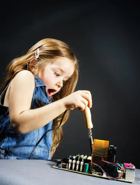 Söt liten flicka reparerar elektronik av cooper-bit — Stockfoto