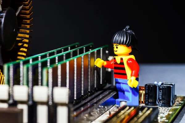 Uomo in miniatura in posa su una scheda madre del computer — Foto Stock