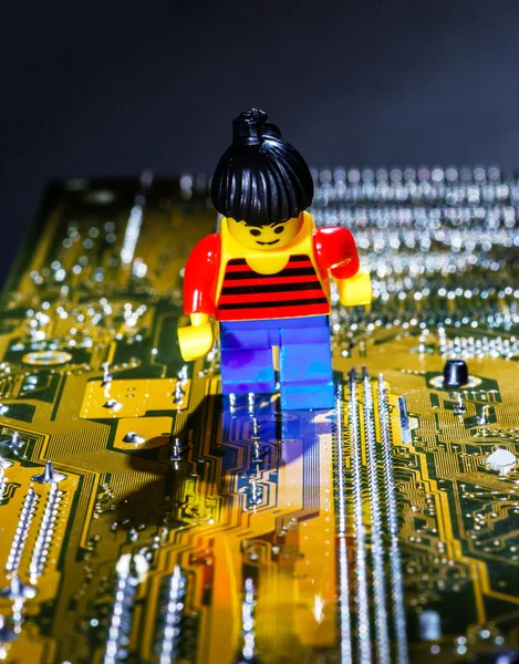 Homem em miniatura posando em uma placa-mãe de computador — Fotografia de Stock