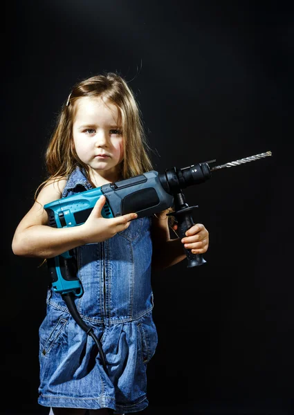 Schattig klein meisje met boren machine in haar handen — Stockfoto