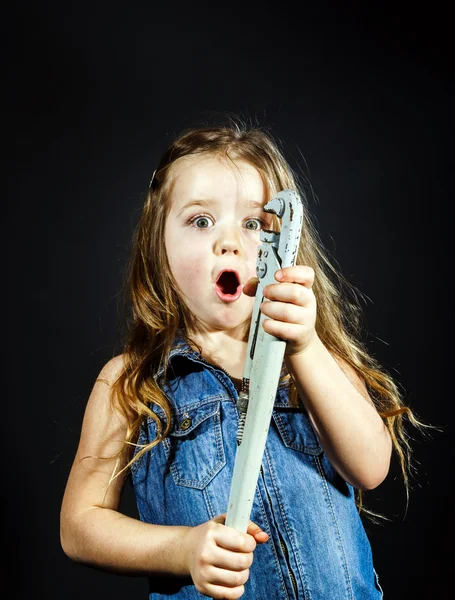 Schattig klein meisje met gas spanner in haar handen — Stockfoto