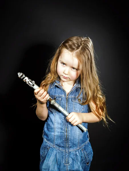 Schattig klein meisje met gas spanner in haar handen — Stockfoto